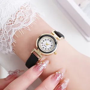 Elegant gold quartz watch with diamond bezel and black leather strap on female wrist