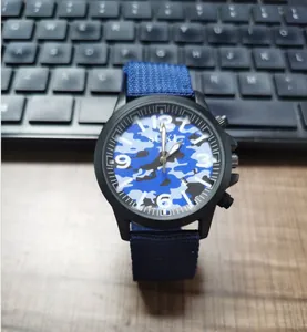 Close-up of SOKI men's quartz watch with blue camouflage dial and nylon strap on keyboard