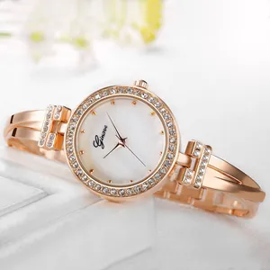Detailed macro view of the rose gold rhinestone bezel and white mother-of-pearl watch dial
