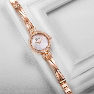 Detail of rose gold fashion watch featuring a rhinestone bezel and twisted metal strap