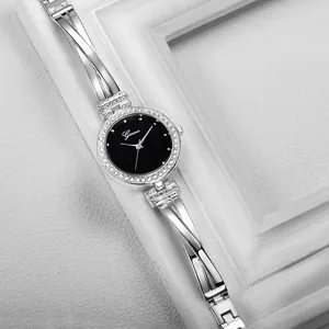 Close-up of elegant silver women's quartz watch with rhinestone bezel and hollow strap