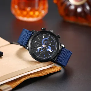 Montre à quartz pour hommes avec bracelet en toile bleue et cadran noir sur un carnet