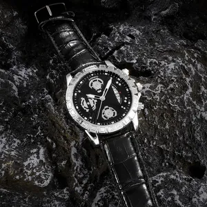 Detail einer silbernen Herrenuhr mit schwarzem Lederarmband auf dunklem Steinuntergrund
