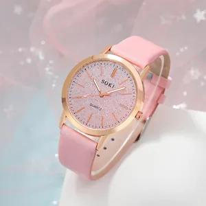 Detail view of a stylish pink leather strap and rose gold quartz watch with a glitter dial