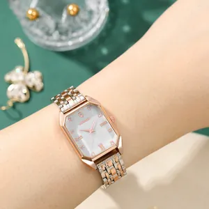 Close-up of rose gold octagonal watch with grey dial and two-tone metal strap on wrist
