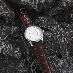 Vista macro orologio al quarzo SOKI con quadrante bianco, calendario e cinturino marrone