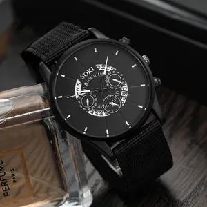 Reloj de cuarzo SOKI negro para hombre con correa de lona resistente sobre mesa de madera