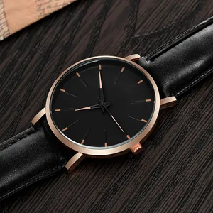 Close-up of minimalist black dial watch with rose gold indices and leather strap
