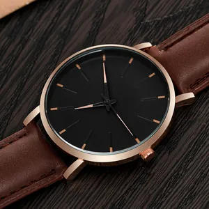 Detail of rose gold case with black dial and brown leather strap on dark wood
