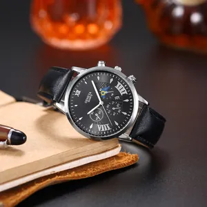 Business quartz watch with black leather strap and triple sub-dials on a brown notebook