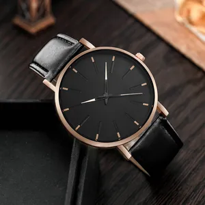 Close-up of minimalist rose gold quartz watch with black leather strap and black dial
