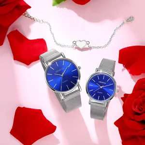 Close-up of couple's watches with blue dials, silver mesh straps and a heart bracelet