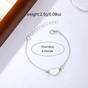 Silver-tone heart pendant bracelet with adjustable chain and minimalist white enamel design