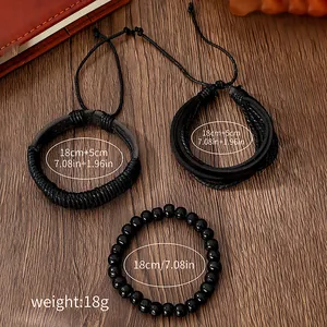 Detail of black woven leather and matte beaded bracelet set on vintage wood background