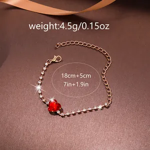 Macro view of gold plated heart bracelet with red gemstone and size specifications