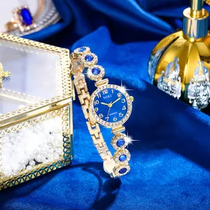 Dettaglio orologio al quarzo dorato con quadrante blu e cristalli su velluto