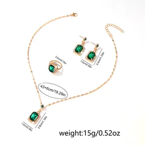 Elegant gold plated jewelry set with emerald rectangular gems and sparkling crystals