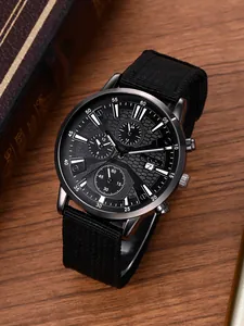 Detail van herenhorloge met zwarte stoffen band en multi-wijzerplaat op houten tafel