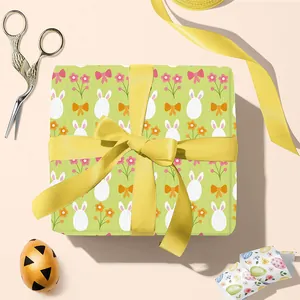 Oster-Geschenkpapier mit weißen Hasen und Blumen auf grünem Grund mit gelber Schleife