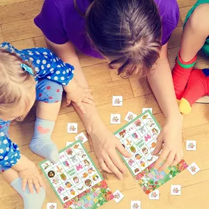 Kids playing Happy Easter bingo game cards with bunny and egg motifs on wooden floor