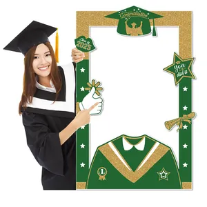 Vertical black and gold graduation photo booth frame with 2025 theme and props