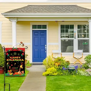 Outdoor Happy Kwanzaa garden flag with vibrant festival symbols and metal stand on a green lawn