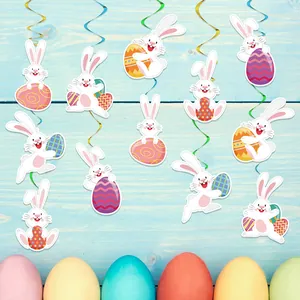 Decorazioni pasquali sospese con coniglietti di carta e uova colorate su legno blu