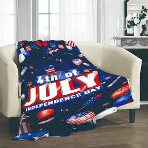 Couverture en flanelle Independence Day avec motifs du 4 juillet sur un canapé blanc