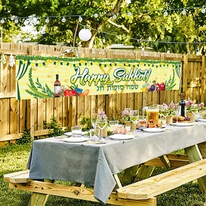 Outdoor Sukkot festival banner with harvest fruit patterns hanging on a wooden fence