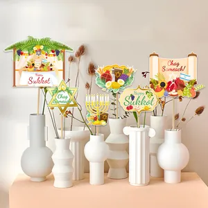Happy Sukkot Jewish holiday table decorations set with festive paper flags in white vases