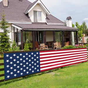 Long Independence Day American flag banner displayed on a backyard garden fence