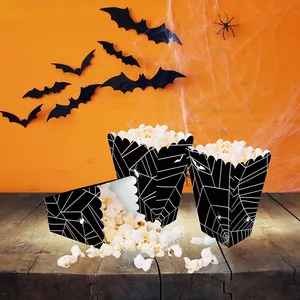 Close-up of Halloween popcorn boxes featuring black spider web and bat designs for parties