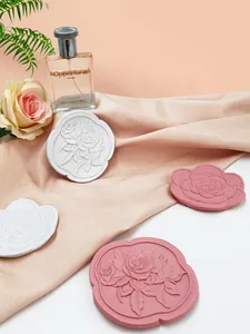 Dettaglio di vassoi per gioielli in resina con rilievo floreale rosa e bianco su seta