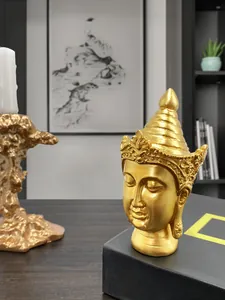 Close-up of golden Buddha head resin ornament with intricate crown and zen aesthetic