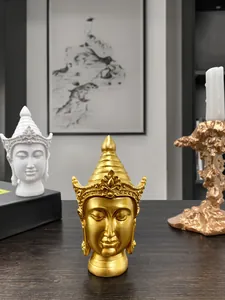 Detailed view of golden and white resin Buddha head sculptures with intricate carving