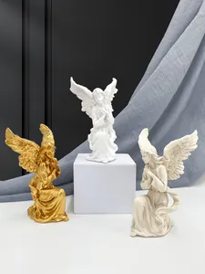 Detailed view of resin angel statues in gold and white with intricate feather textures