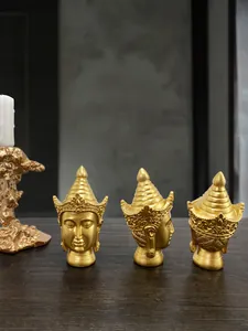 Three-view perspective of a golden resin Buddha head statue on a dark wood table
