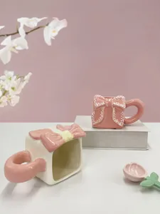 Dettagli di tazze in ceramica con fiocchi 3D e un cucchiaio a forma di tulipano rosa