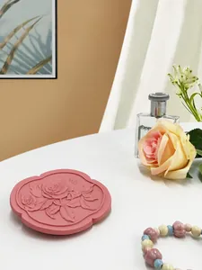 Dettaglio del vassoio portagioie in resina rosa con rose in rilievo per fotografia