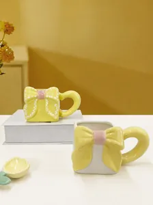 Detail of creative ceramic mug featuring 3D bow design and petal-shaped stirring spoon