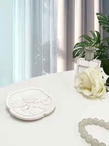 Dettaglio vassoio portagioie bianco con eleganti rilievi di rose e bordo a fiori