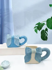 Dettaglio di una tazza quadrata in ceramica con fiocco 3D e grande manico rotondo