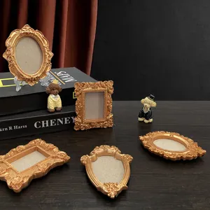 Five-piece vintage gold baroque miniature frames set with floral relief on dark wood