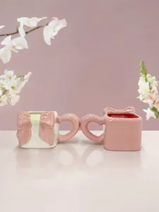 Dettaglio delle tazze in ceramica con fiocchi fatti a mano e manici a forma di cuore