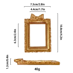 Detailed view of mini golden vintage photo frame with bow detail and ornate scrollwork