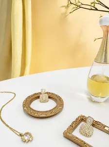Detailopname van pareloorbellen en diamanten ketting in een vintage gouden reliëflijst