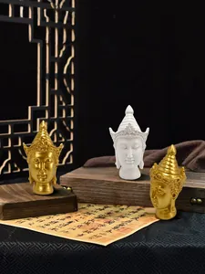 Detailed close-up of Zen Buddha head statues in gold and white with intricate resin crowns