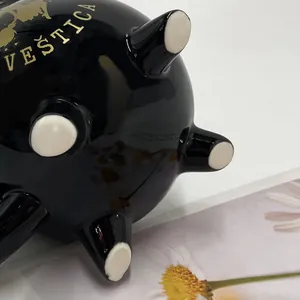 Detailansicht des Bodens der schwarzen Hexen-Tasse mit vier Füßen und goldener Aufschrift
