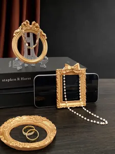 Close-up of vintage gold embossed photo frames and pearl jewelry set with a baroque finish