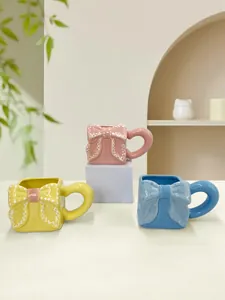 Dettaglio della tazza in ceramica fatta a mano con fiocco e texture in rilievo rosa